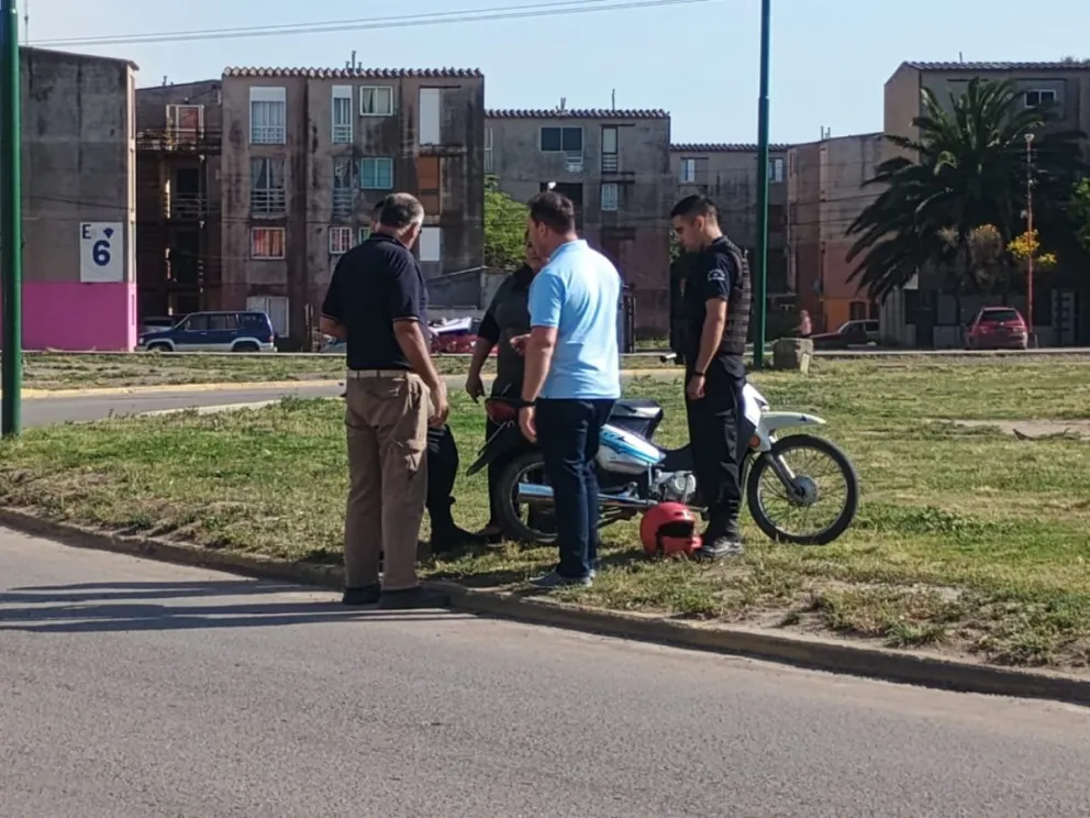 Personal de la policía y vecinos junto a la moto que protagonizó el siniestro.