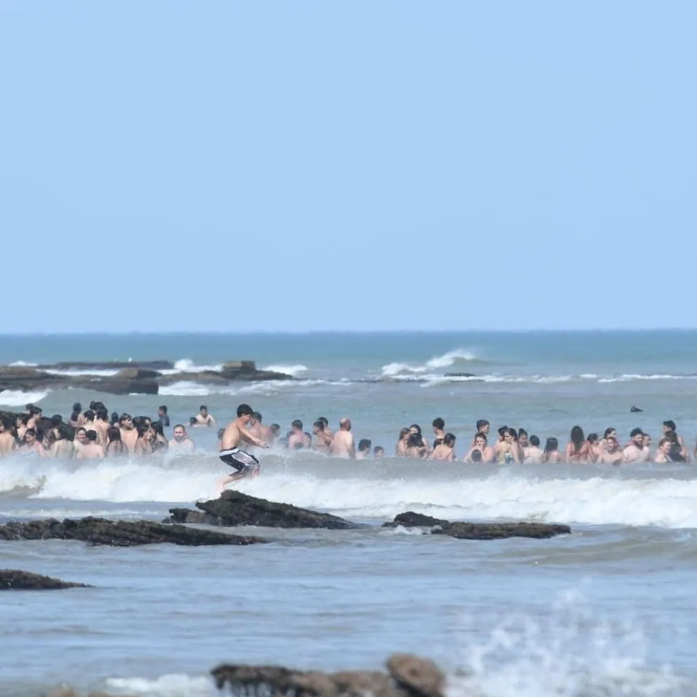 Turistas y lugareños disfrutan de un día de playa en la costa altántica.