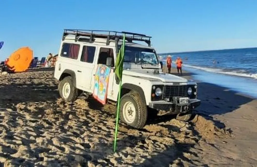 Jeep en un lugar no permitido, al costado de las personas de a pie con sus reposeras. 
