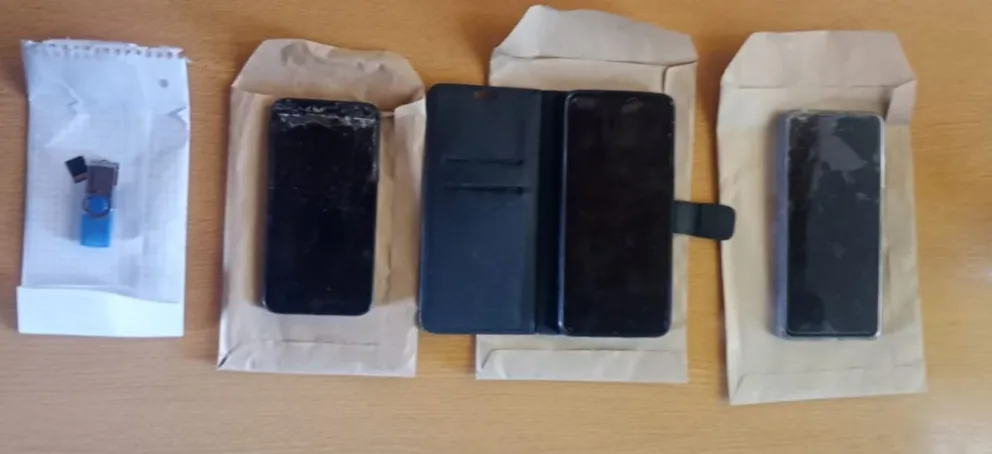 Tres teléfonos celulares y una tarjeta de memoria.
