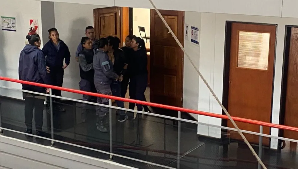 La imputada siendo contenida por varios policías 