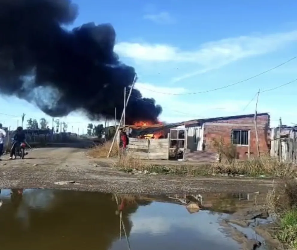 Fuego en una vivienda de la Toma 2 de Enero de Viedma. Bomberos trabajan con velocidad para disminuir el siniestro, donde habría una significativa destrucción de bienes. Foto e imágenes gentileza: Taxistas en Movimiento. 