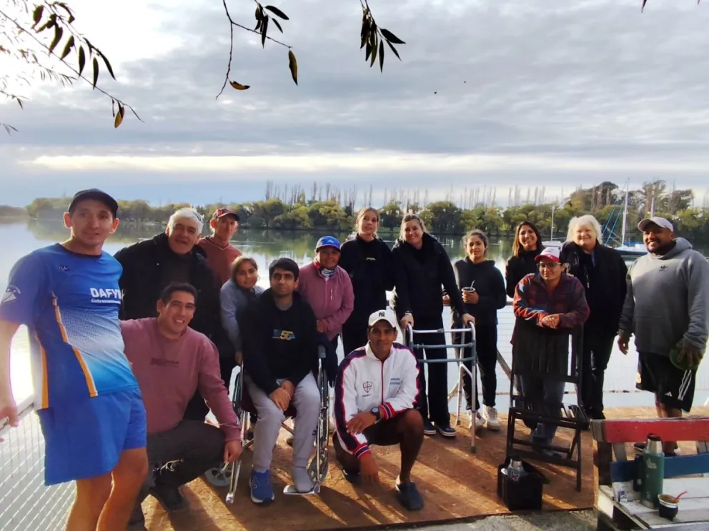 Marcelo Barra, en el centro, acompañado de integrantes del club Náutico La Ribera. que él preside. Detrás una postal del río Negro. Foto gentileza.