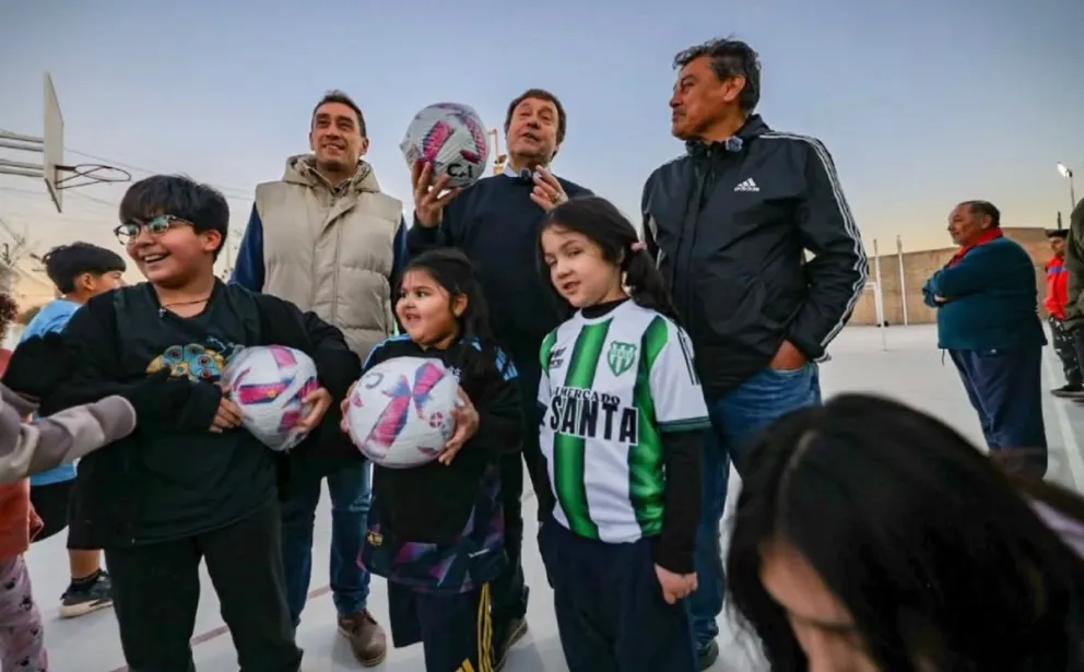 El gobernador Alberto Weretilneck, el intendente Marcos Castro y el presidente del club barrial Luis Coronado, en medio de la alegría de los niños que ya disfrutan del playón en Santa Clara. Fotos: @rionegrogob
