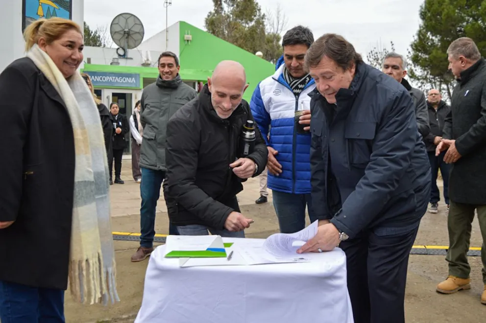 El gobernador, Alberto Weretilneck, el ministro de Obras Públicas, Alejandro Echarren, y el presidente del Club deportivo San Javier, firmando el acuerdo. Foto: Emanuel Mirenghi