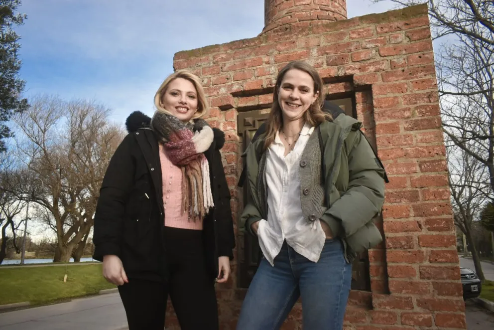 Elena (izquierda) y Clarisa (derecha). Detrás, la postal del río Negro y un emblema itálico: el monumento a Garibaldi. Fotos Vanesa Schwemmler para NoticiasNet.